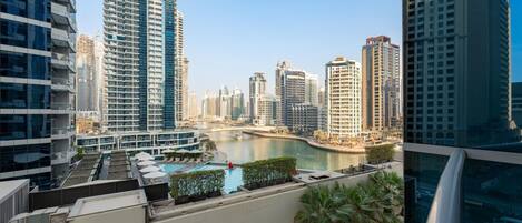 A high-rise building with a view of a river and other city buildings.