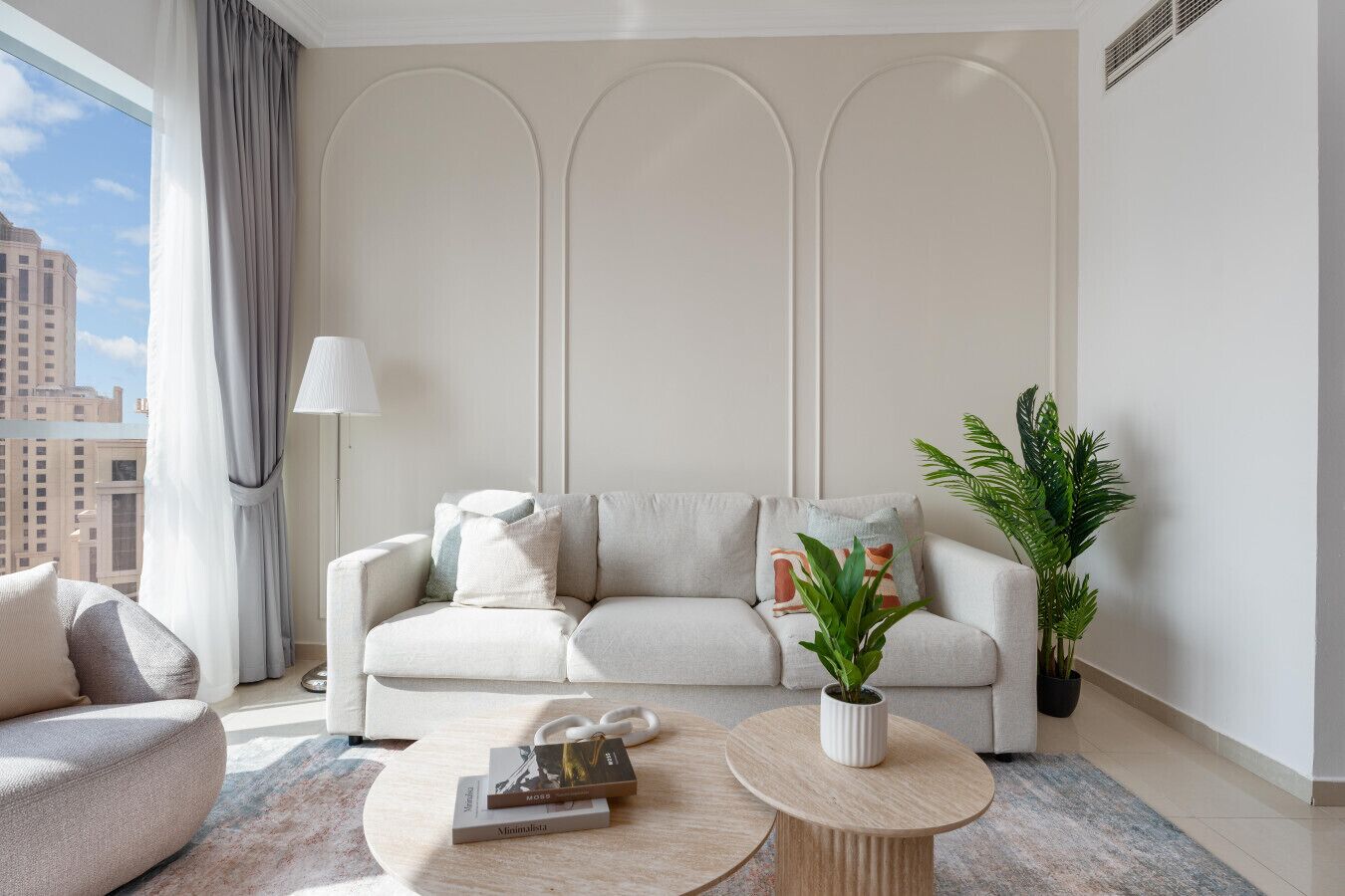A modern living room with a sofa, a coffee table, and a potted plant.