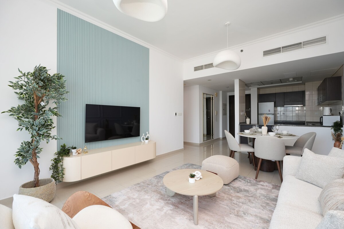 Ein modernes Wohnzimmer mit Flachbildfernseher, Essbereich und Küche.