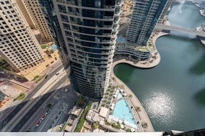 Ein Hochhaus mit geschwungener Fassade, einem Schwimmbad und einem Fluss.