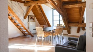 A dining area with a table and chairs, a sofa, and a wooden ceiling structure. - Apartment 'Ferienwohnung Wintersulgen' with Wi-Fi (Heiligenberg)