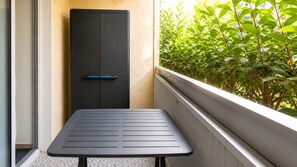 A balcony with a table and a door, surrounded by greenery. - Cozy studio in Dramont, 300m from the beach (Saint-Raphaël)