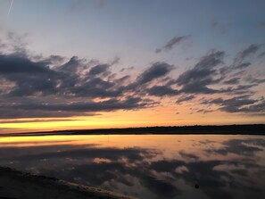 Un tramuntana sobre una calma extensió d'aigua, amb núvols reflectits a la superfície.