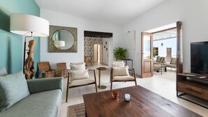 A living room with a sofa, chairs, a coffee table, a TV, and a large mirror. - Villa Roseta by Escape Home (Puerto del Carmen)