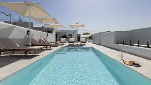 A rooftop pool with lounge chairs and umbrellas, surrounded by white walls and cacti. - Villa Roseta by Escape Home (Puerto del Carmen)