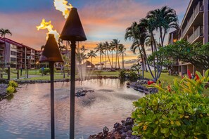 A hotel with a pool, palm trees, and a sunset view. - Remodeled Ground Floor 2BR Steps to Pool & Hot Tub -Papakea K105 (Lahaina)