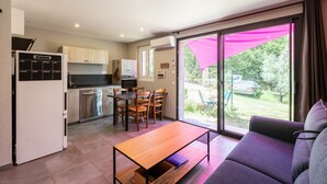 Una cucina moderna con zona pranzo, divano e una porta scorrevole in vetro che dà sull'esterno.