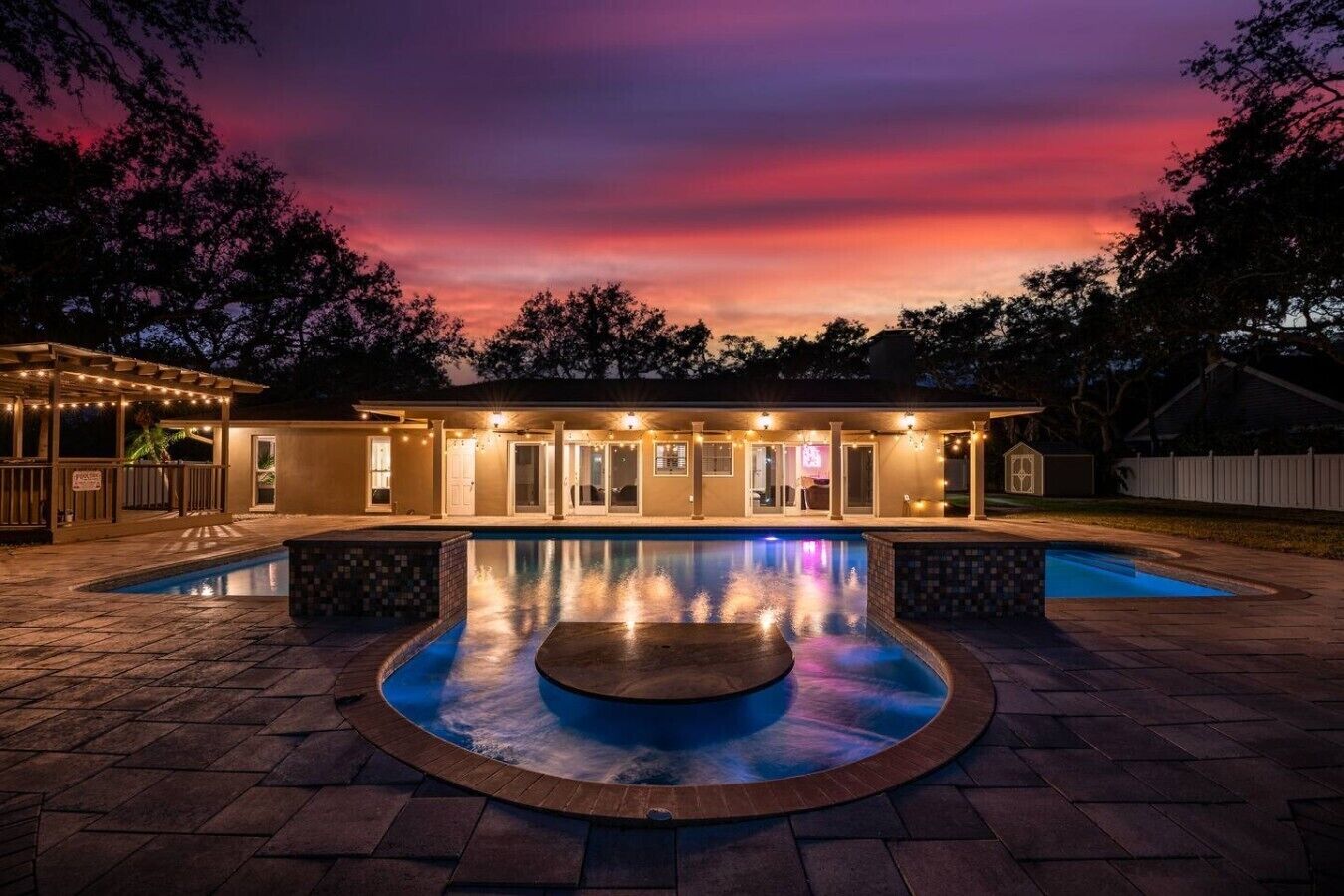 Una casa con piscina, patio coperto e cortile recintato.