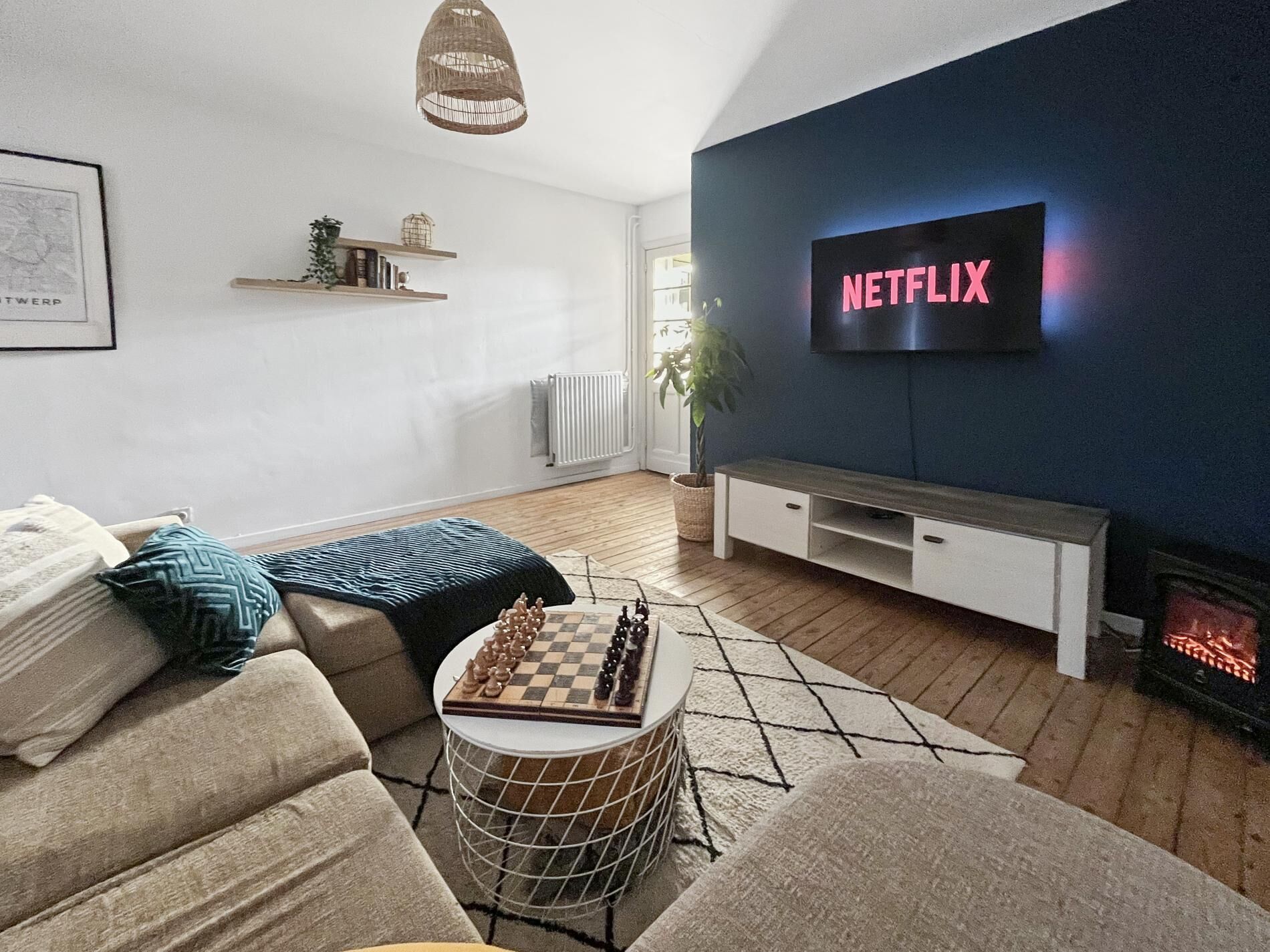 Bright and inviting living room with a comfortable sofa, large smart TV for streaming, and warm wooden floors. Natural light fills the space, while the cozy seating area and electric fireplace create a relaxed setting for unwinding after a day in the city