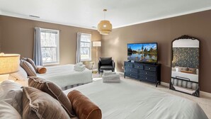 A hotel room with two beds, a television, a dresser, and a mirror. - 3000sqft 5B3.5B Retreat Near Lenovo Center - Upscale 3 King Beds (Cary)