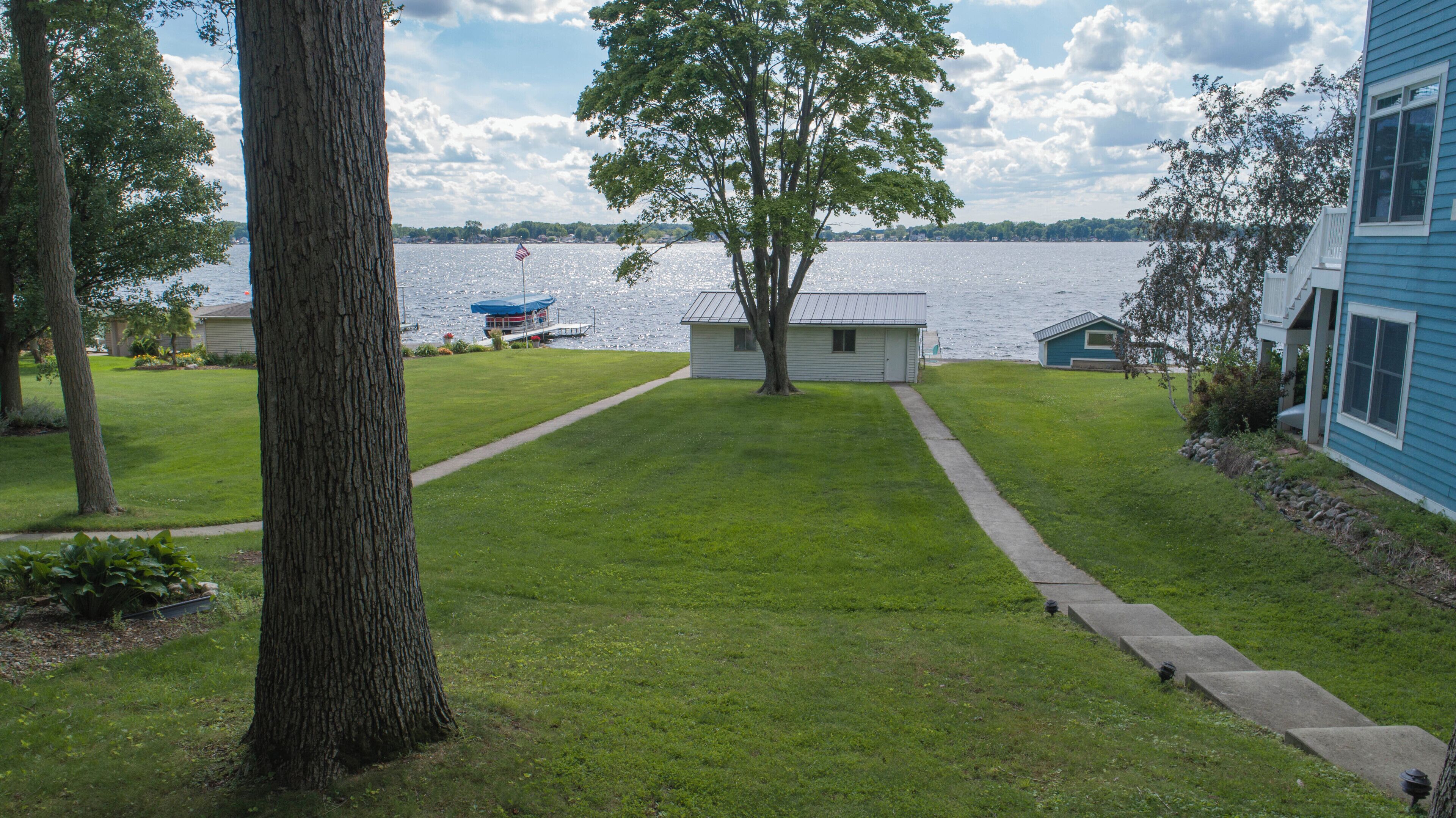A residential property with a lawn, a dock, and a view of a lake.