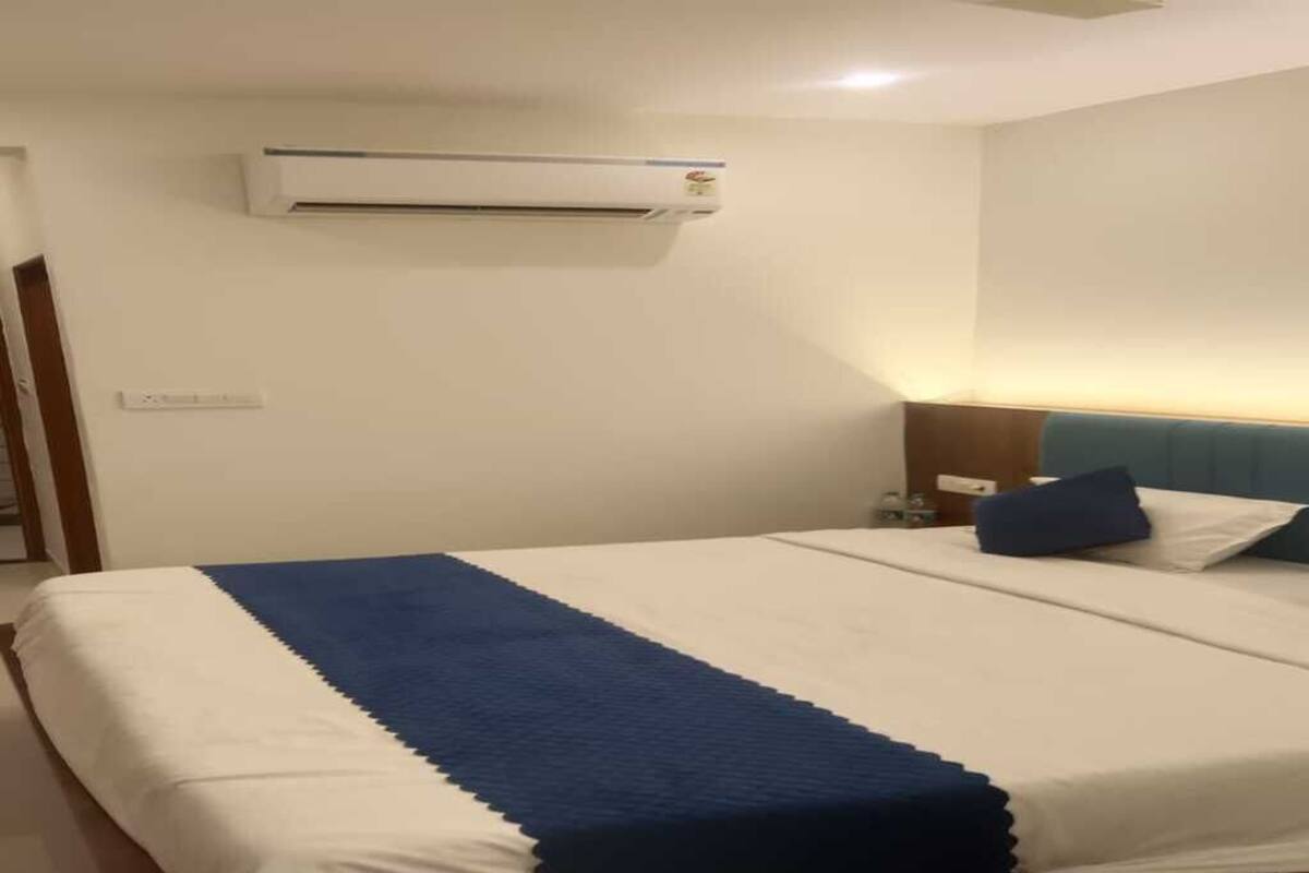 Habitació d'hotel amb un llit, aire condicionat, una nit i una làmpada penjada a la paret.