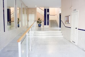 A clean, modern interior with a staircase leading to upper floors, a wooden handrail, and a potted plant. - Lentiscares 212 by At Home Costa del Sol (Torrox)