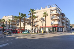 A multi-story building with balconies, palm trees, and storefronts including a Santander bank. - Lentiscares 212 by At Home Costa del Sol (Torrox)