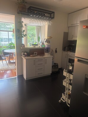 Eine moderne Küche mit Einbauofen, Kühlschrank und Essbereich mit Tisch und Stühlen.
