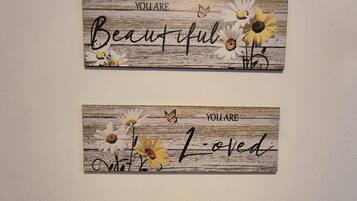 Three wall-mounted signs with positive affirmations and floral designs.