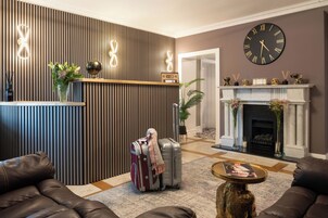 Una sala de estar moderna con chimenea, un reloj y un mostrador de recepción.