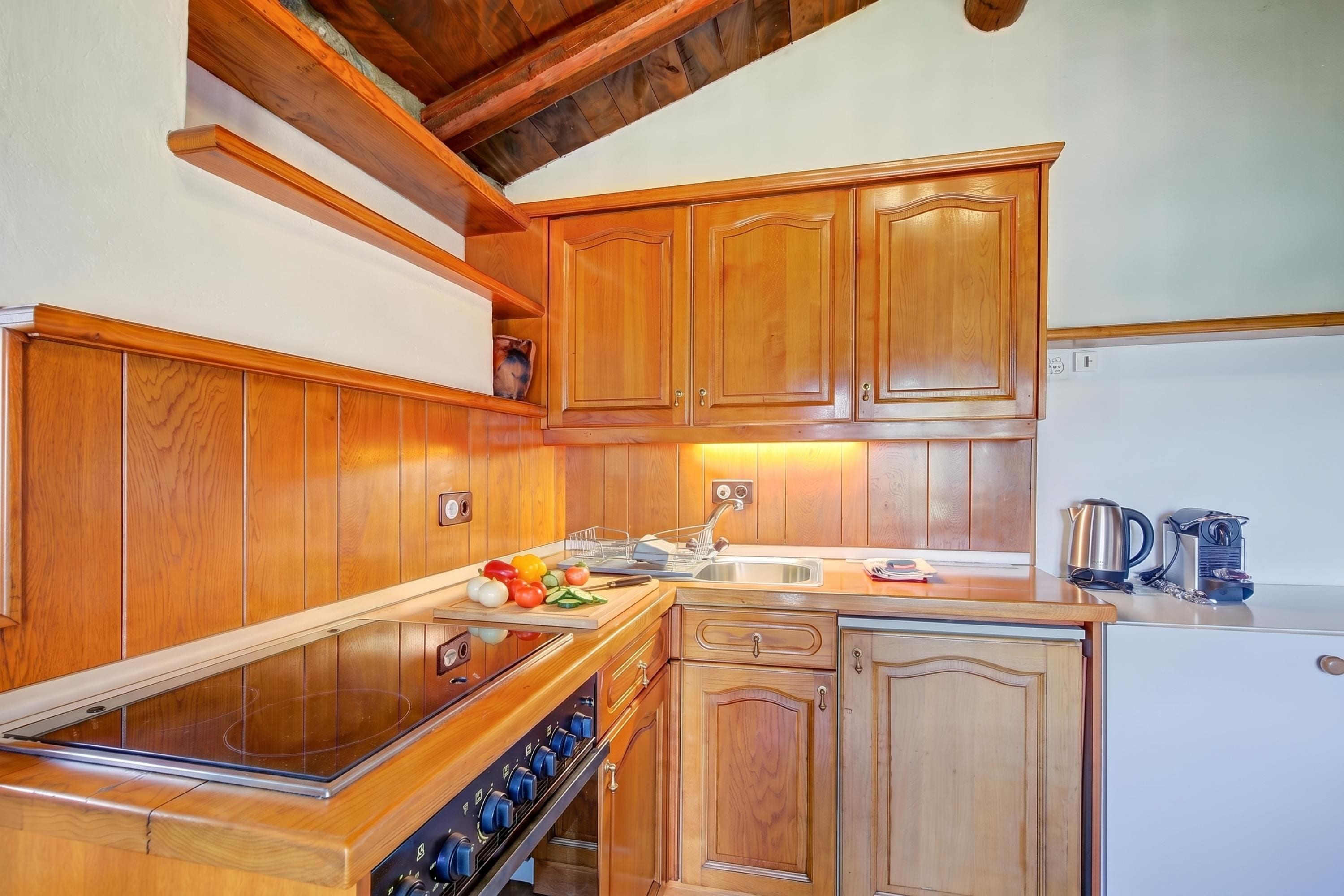 Una cocina con armarios de madera, una estufa y un lavabo.