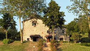 A stone building with a rustic appearance, surrounded by trees and greenery. - Tenuta Valdea (Firenzuola)