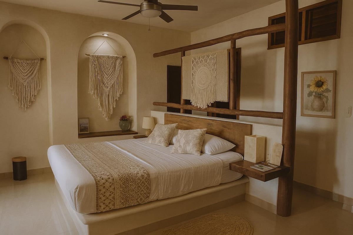 Une chambre à coucher avec un grand lit, une tête de lit en bois, des décorations murales en macramé et un ventilateur de plafond.