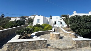 A white building with a stone pathway and a clear blue sky. - Casa Bianca Mykonos (Ornos)