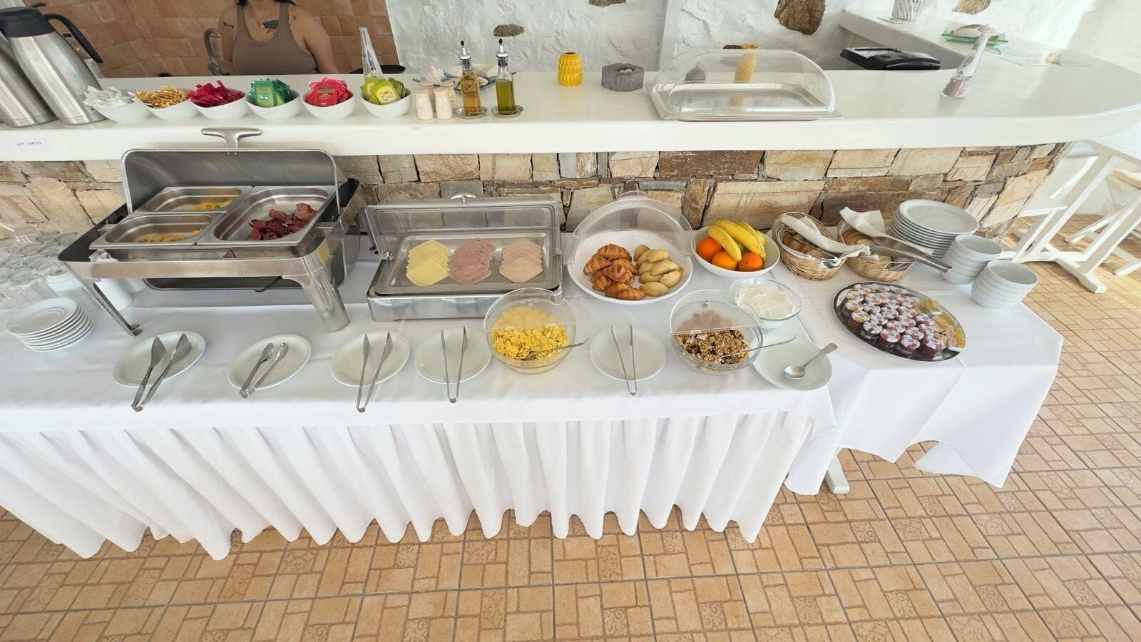 A buffet table with various food items and utensils.