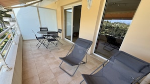 A balcony with two lounge chairs, a table, and chairs. - Bay view Cavalaire sur Mer - Pretty T3 Air-conditioned Top floor Swimming pool Classified **** (Cavalaire sur Mer)