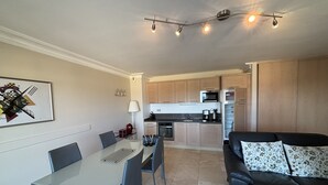 A compact living space with a dining area, a kitchenette, and a seating area. - Bay view Cavalaire sur Mer - Pretty T3 Air-conditioned Top floor Swimming pool Classified **** (Cavalaire sur Mer)