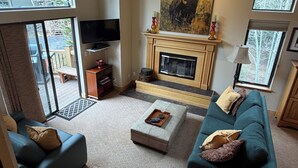 Ein Wohnzimmer mit Kamin, Fernseher und einer Couch.