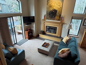 Ein Wohnzimmer mit Kamin, Fernseher und einer Couch.