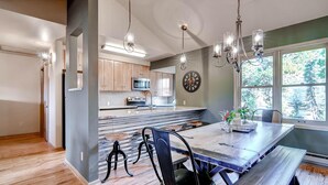 A modern kitchen with wooden cabinets, a large island, and pendant lighting. - Huge Views|Free Shuttle 1/2 Block|Wood Fireplace (Breckenridge)