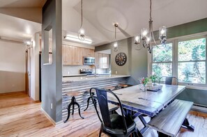 A modern kitchen with wooden cabinets, a large island, and pendant lighting. - Huge Views|Free Shuttle 1/2 Block|Wood Fireplace (Breckenridge)