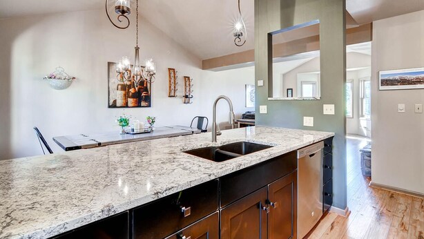 A kitchen with a marble countertop, a sink, and a modern chandelier. - Huge Views|Free Shuttle 1/2 Block|Wood Fireplace (Breckenridge)