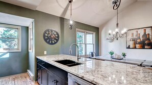 A kitchen with a marble countertop, a built-in dishwasher, a wall clock, and a chandelier. - Huge Views|Free Shuttle 1/2 Block|Wood Fireplace (Breckenridge)