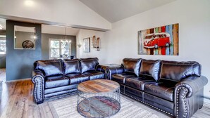 A modern living room with a sectional sofa, a round coffee table, and a large abstract painting. - Huge Views|Free Shuttle 1/2 Block|Wood Fireplace (Breckenridge)