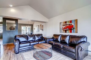 A modern living room with a sectional sofa, a round coffee table, and a large abstract painting. - Huge Views|Free Shuttle 1/2 Block|Wood Fireplace (Breckenridge)