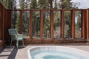 A wooden cabin with a hot tub and a view of a forest. - Pool|2 Hot Tubs|Garage|Fireplace|Elevator|Balcony (Breckenridge)