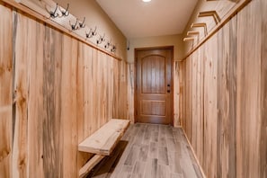A hallway with wooden walls, a bench, and a door at the end. - Pool|2 Hot Tubs|Garage|Fireplace|Elevator|Balcony (Breckenridge)