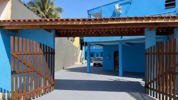 Uma entrada protegida por grades para um edifício com fachada azul e telhado em telhas.
