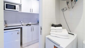 Eine moderne Küche mit Mikrowelle, Spüle und einem kompakten Kühlschrank.