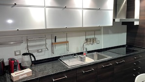 A modern kitchen with a stainless steel sink, a coffee maker, and a dish rack. - Luxury Apartment, Near Beach&golf (Seixal)