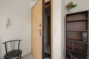 A room with a wooden door, a telephone, a chair, and a bookshelf. - Apartment 'Happiness in Chania' with Wi-Fi (Chania)