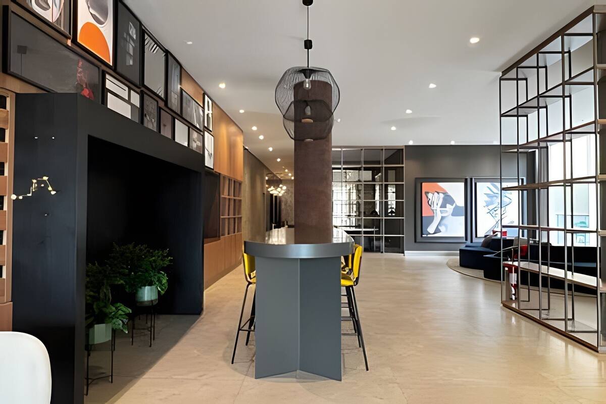 Un interior moderno con una columna central, zona de estar y estanterías.
