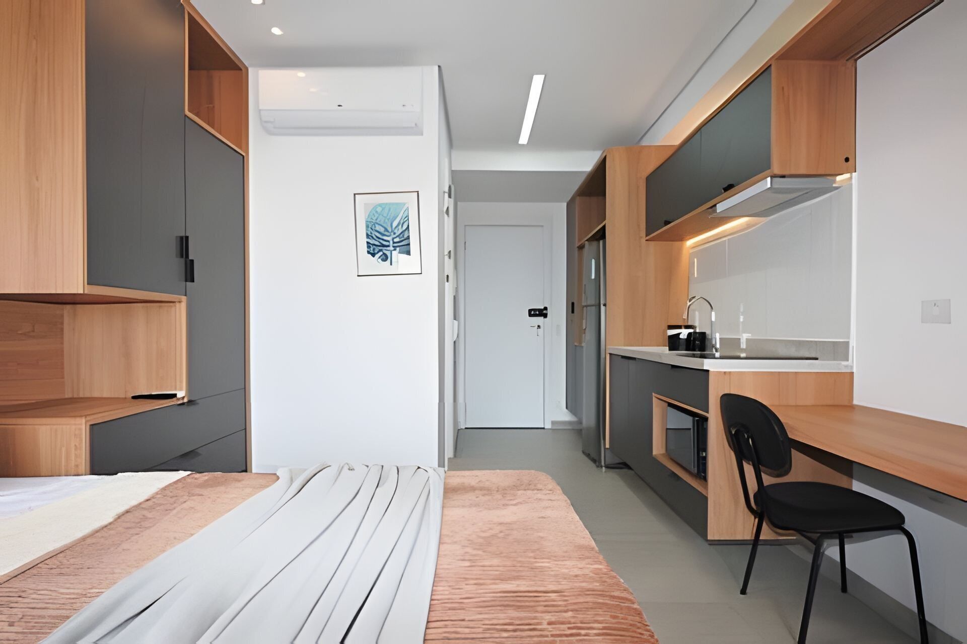 A modern kitchen with a built-in stove, a sink, and a black chair.
