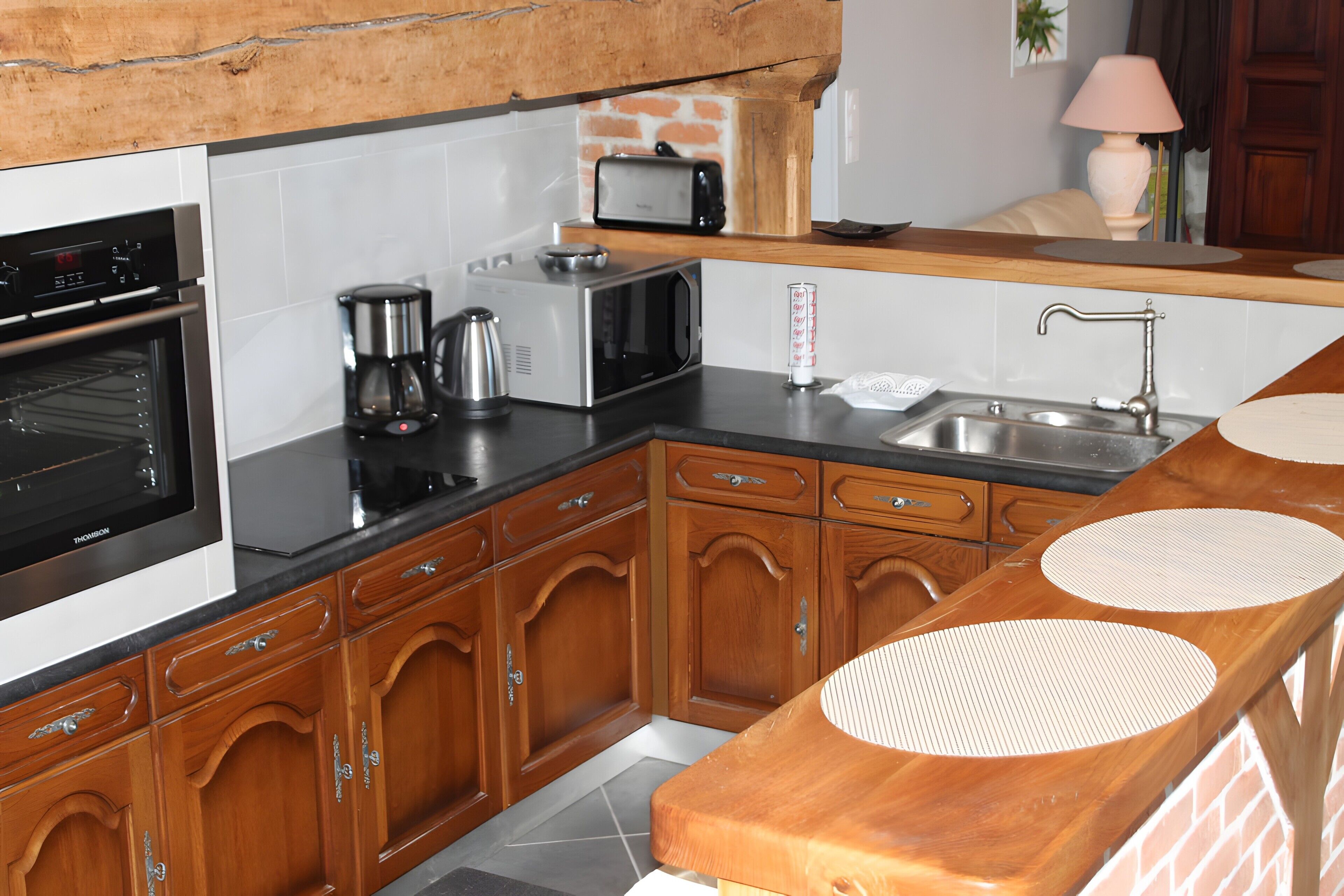 Eine Küche mit Holzausstattung, einer Mikrowelle, einem Toaster und einer Kaffeemaschine.