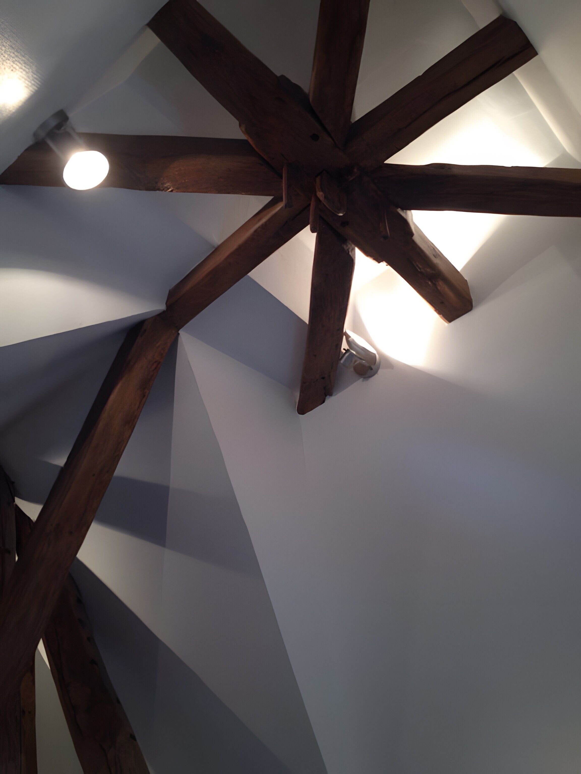 A ceiling with wooden beams and a light fixture.