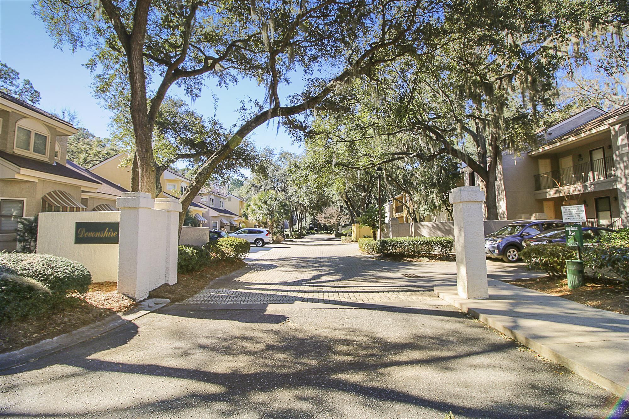 A residential street with houses, a driveway, and a sign that reads 'Deronshire.'