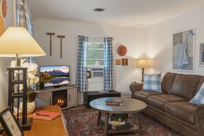A cozy living room with a fireplace, a television, a sofa, and a coffee table.