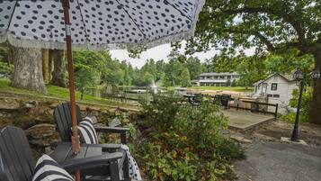 Buitenplaats met zitgelegenheid, uitzicht op een meer en een gebouw op de achtergrond.
