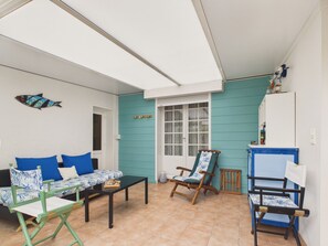 A room with a sofa, a table, a chair, and a window. - House for 4, 1 km from beach, garden & BBQ (Les Portes-en-Ré)